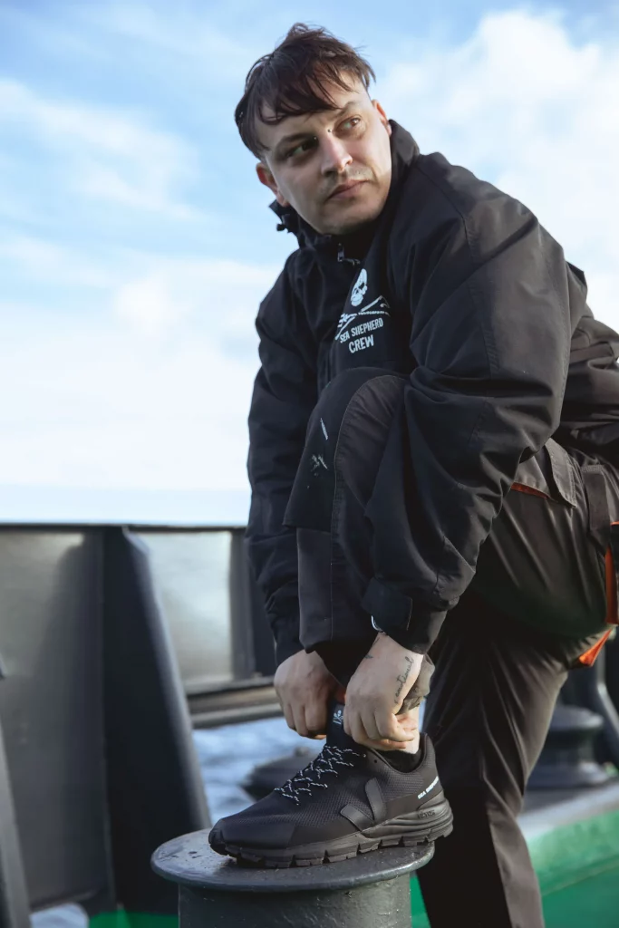 Marin portant des baskets Veja Sea Shepherd